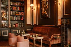 a library with a couch and two tables and bookshelves at The William powered by Sonder in New York