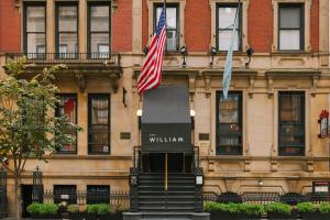 dos banderas volando delante de un edificio en The William powered by Sonder en Nueva York