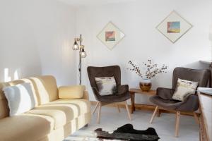 ein Wohnzimmer mit einem Sofa und 2 Stühlen in der Unterkunft HelloChalet - Foyer du Cervin 250m skiruns in Breuil-Cervinia