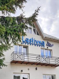 um edifício com um sinal na lateral em Lastivka Guest House em Yablunytsya