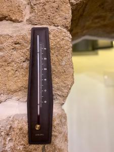 een thermometer aan de zijkant van een stenen muur bij Bab al-sham funduk in Akko