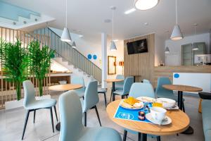 a dining room with tables and chairs and a staircase at Lizbon South Bed in Barreiro