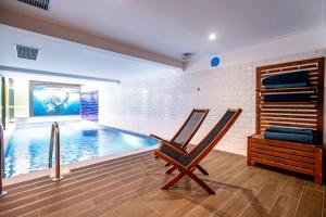 two chairs sitting in front of a swimming pool at Lizbon South Bed in Barreiro