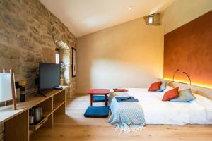 a bedroom with a large bed and a tv at Hotel japonès Puigpinós in Lladurs