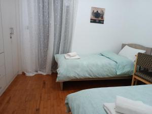- une petite chambre avec 2 lits et une fenêtre dans l'établissement Spiri's House-Deluxe Apartment in Kalabaka-Meteora, à Kalambaka