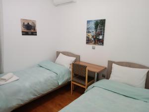 een kamer met 2 bedden en een tafel met een stoel bij Spiri's House-Deluxe Apartment in Kalabaka-Meteora in Kalabaka