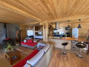 uma sala de estar com um sofá e uma cozinha em Chalet Miel de la Cayolle-Estenc em Entraunes