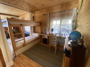 ein Schlafzimmer mit einem Etagenbett und einem Schreibtisch in einem Zimmer in der Unterkunft Chalet Miel de la Cayolle-Estenc in Entraunes