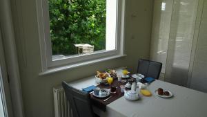 - une table avec de la nourriture et une fenêtre dans l'établissement B&B Maaltebrug, à Gand