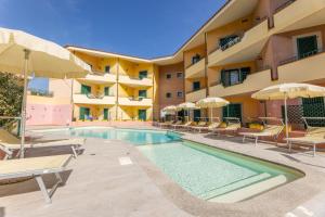 una piscina en un hotel con sillas y sombrillas en Residence I Mirti Bianchi, en Santa Teresa Gallura