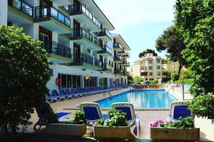 a view of a hotel with chairs and a swimming pool at Guya Wave Hotel in Cala Ratjada
