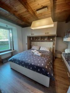 um quarto com uma cama grande num quarto com tectos em madeira em Appartamento gaiulin em Pinzolo