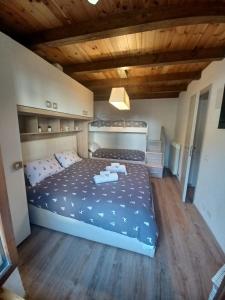 um quarto com uma cama grande num quarto com tectos em madeira em Appartamento gaiulin em Pinzolo