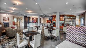 a kitchen and living room with tables and chairs at Hotel Indigo Jacksonville-Deerwood Park, an IHG Hotel in Jacksonville