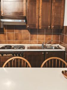 a kitchen with wooden cabinets and a stove and a sink at Apartment HM in Gozd Martuljek