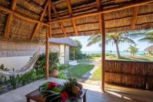 a porch with a hammock and a view of the ocean at Casa Cabana Beach in Vilanculos