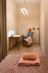 a bedroom with a desk and a table and a chair at Dorpat Apartment in Tartu