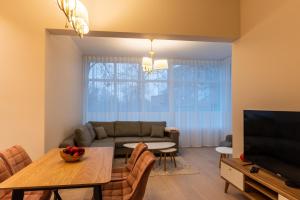 uma sala de estar com um sofá e uma mesa em Dorpat Apartment em Tartu