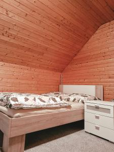 a bedroom with a large bed in a wooden wall at Apartment HM in Gozd Martuljek