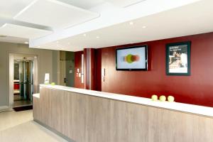 a lobby with a bar with a tv on the wall at Campanile Marne la Vallée - Bussy Saint-Georges in Bussy-Saint-Georges