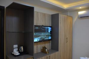 een kamer met een televisie in een kast bij Jewel Green Mountain Hotel in Caïro