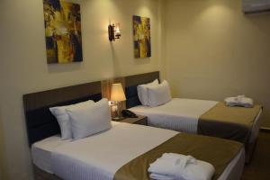 a hotel room with two beds with towels on them at Jewel Green Mountain Hotel in Cairo