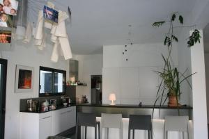 a kitchen with white cabinets and a table with chairs at Villa Alberes Sorede 7 km of beaches in Sorède