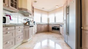 uma cozinha com armários brancos e uma grande janela em Penthouse Vistamar em Chayofa