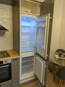 a refrigerator with its door open in a kitchen at Maria Deluxe Central Apartment in Timişoara