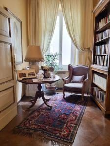 uma sala de estar com uma mesa, uma cadeira e uma janela em Casa Masoli em Ravenna