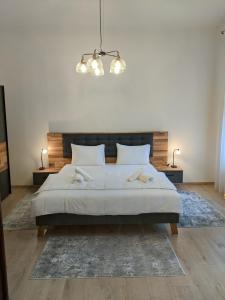 sypialnia z dużym łóżkiem i żyrandolem w obiekcie Maria Deluxe Central Apartment w mieście Timişoara