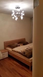 Schlafzimmer mit einem Bett mit einem Kronleuchter an der Decke in der Unterkunft Messeappartment Nürnberg in Nürnberg