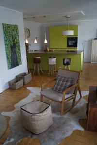 ein Wohnzimmer mit einem Sofa und Stühlen sowie eine Küche in der Unterkunft Ferienwohnung Moselschön in Brodenbach