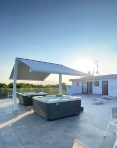 a pavilion with two hot tubs on a patio at Appartamenti Vanin in Cavallino-Treporti