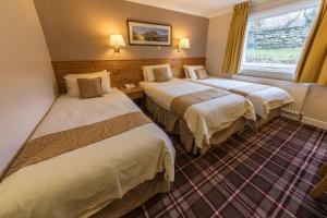 a hotel room with two beds and a window at Norseman Hotel in Wick