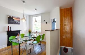 a dining room with a table and green chairs at Arthouse Canterbury-Free Secure Parking in Canterbury