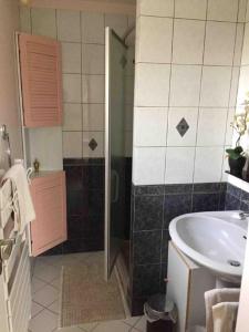 La salle de bains est pourvue d'une douche, d'un lavabo et d'une baignoire. dans l'établissement Maison Chevreuse, chambre chez l'habitant, à Magny-les-Hameaux