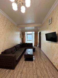 uma sala de estar com um sofá e uma televisão de ecrã plano em Apartment on Khimshiashvili 1 em Batumi