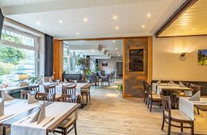 a dining room with tables and chairs and windows at Hotel-Gasthof zum Ritter in Haßmersheim