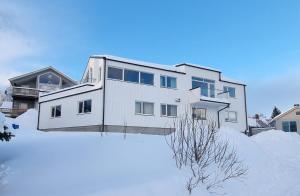 a white house in the snow with a yard at Staying Apt 3 - New and modern in Tromsø