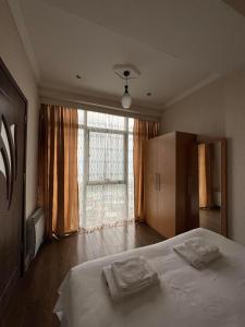 a bedroom with a bed with two towels on it at Apartment on Khimshiashvili 1 in Batumi