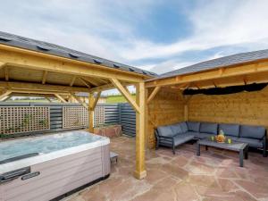 a patio with a hot tub and a pergola at Westertonhill Lodges in Balloch