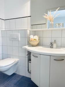 Baño blanco con lavabo y aseo en Das Ruebezahl, en Reit im Winkl