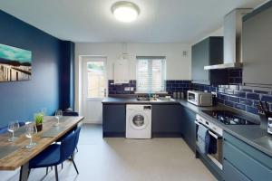 uma cozinha com uma mesa e uma máquina de lavar roupa em HU-Nine Dock House - Sleeps 4 em Hull