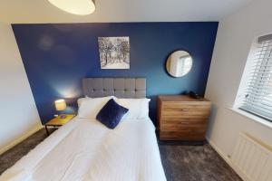 a bedroom with a white bed and a blue wall at HU-Nine Dock House - Sleeps 4 in Hull