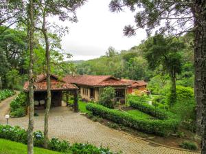 a house in the middle of a garden at Casa de campo Hortencia com piscina e lazer - RJ in Teresópolis