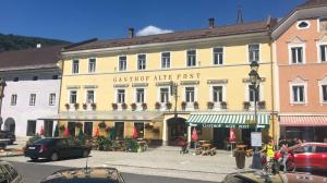 ein großes gelbes Gebäude mit einem Café davor in der Unterkunft Gh Alte Post - Top 5 Gt in Gmünd in Kärnten