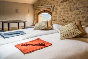 1 dormitorio con 2 camas con almohadas y mesa en Hotel japonès Puigpinós, en Lladurs