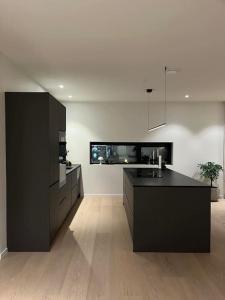 a kitchen with a black counter and a sink at North Apartment in Tromsø