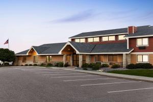 un edificio con un estacionamiento delante de él en AmericInn by Wyndham Sauk Centre, en Sauk Centre